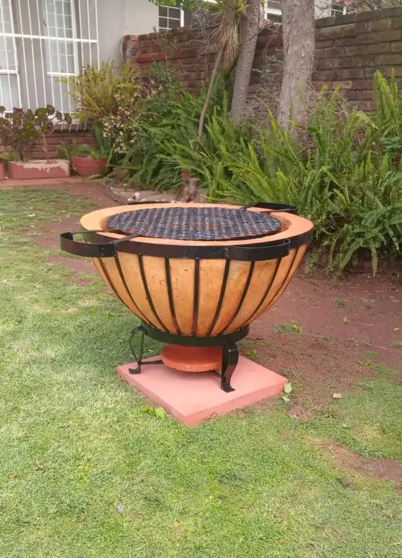 Handcrafted braai boma on a garden lawn