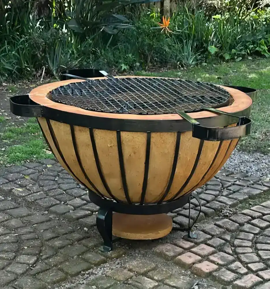 Large bowl-shaped braai boma on stone paving